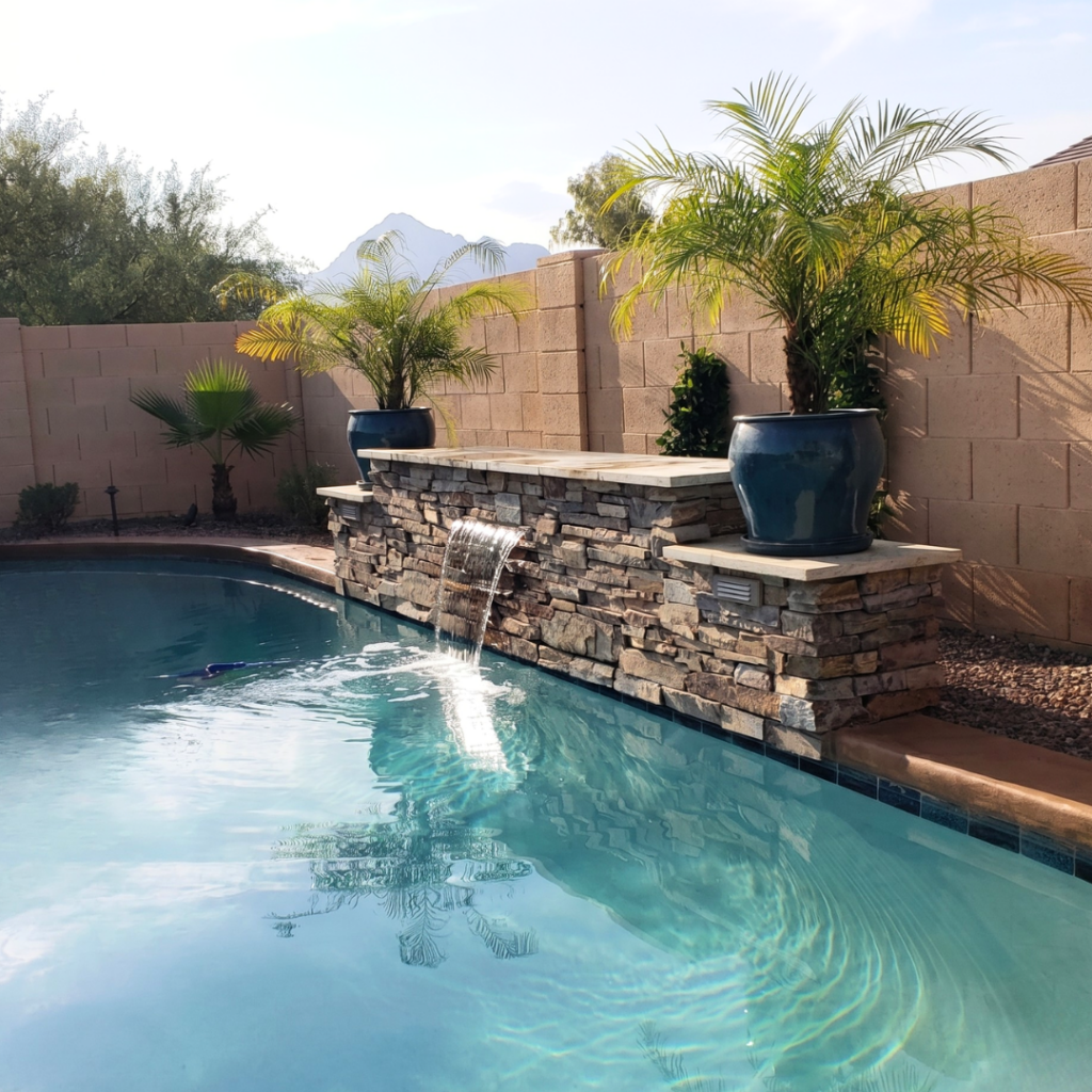 Pool with stacked stone water spillway and palm trees
