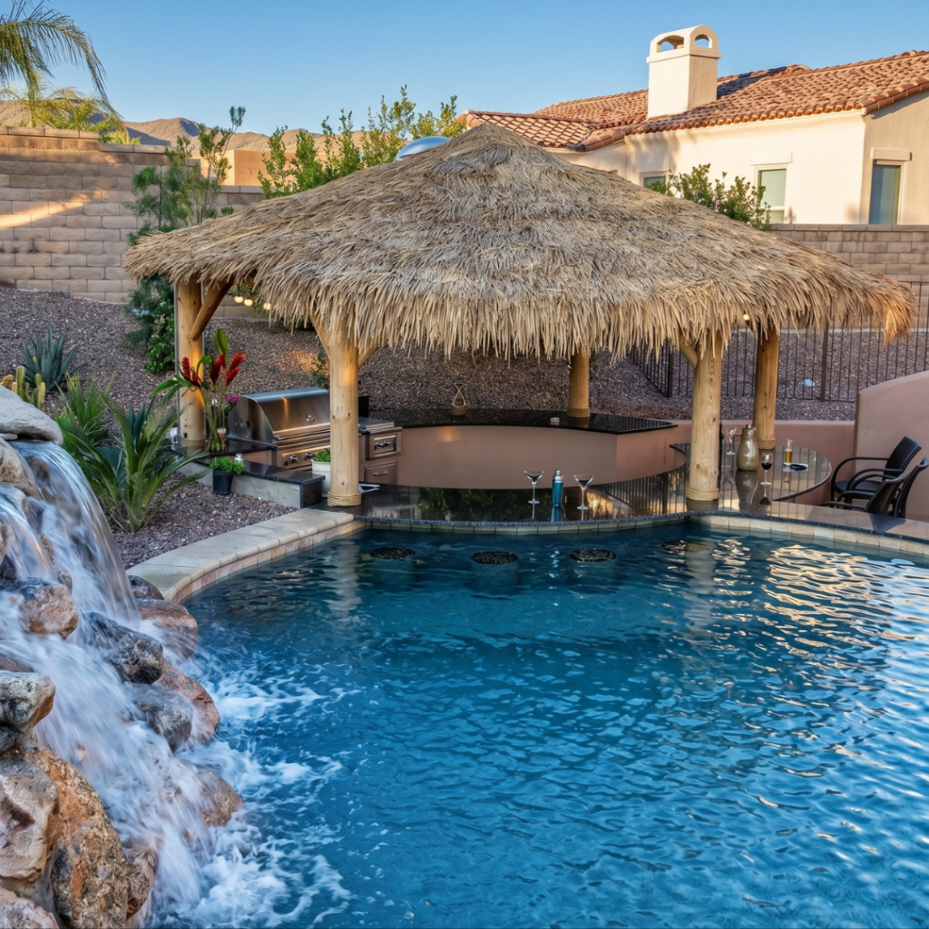 Pool with stone waterfall and thatched-roof tiki bar with grill